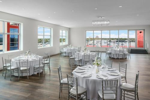 a banquet hall with white tables and chairs and windows at Costa Hollywood Beach Resort - An All Suite Hotel in Hollywood