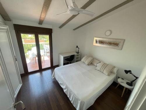 1 dormitorio con 1 cama y ventilador de techo en Los Álamos, casa de campo cerca de Madrid, en Chiloeches