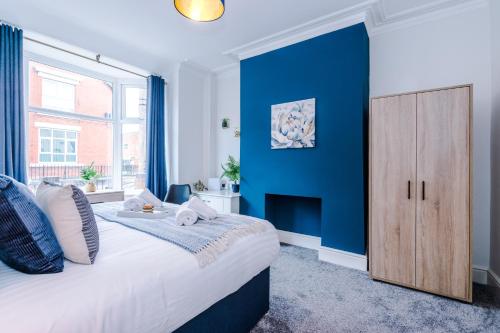 a bedroom with a blue accent wall and a bed at Spacious 4-bed house in Crewe by 53 Degrees Property, ideal for Business & Contractors - Sleeps 7 in Crewe