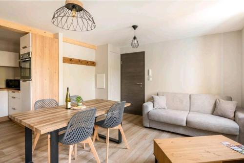 uma sala de estar com uma mesa e cadeiras e um sofá em Le NATURE 1 Chambre et sauna em Colmar