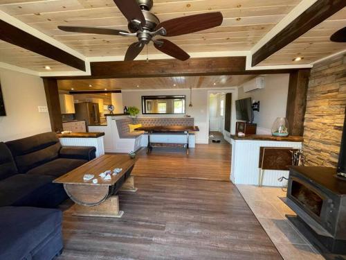 - un salon avec un canapé et un ventilateur de plafond dans l'établissement Bespoke Lake Cottage, à New Minas