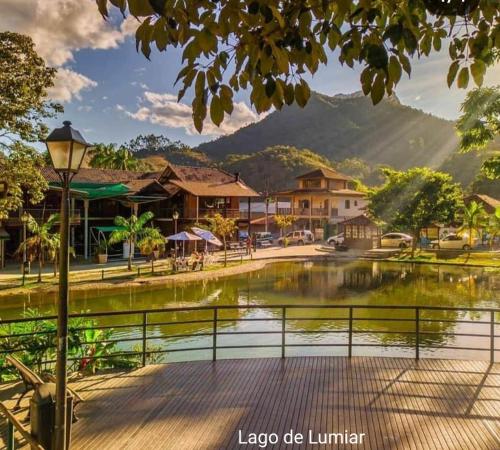 una ciudad con un lago, edificios y una montaña en Pousada Bem Te Vi Lumiar en Lumiar
