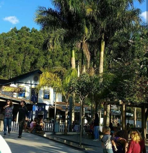a group of people standing around a building with palm trees at Pousada Bem Te Vi Lumiar in Lumiar