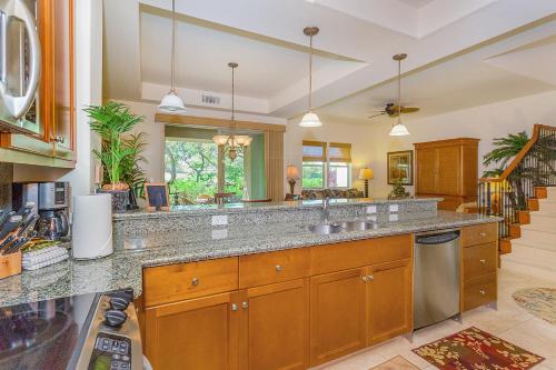 a large kitchen with wooden cabinets and a counter top at Fairways at Mauna Lani by South Kohala Management in Waikoloa