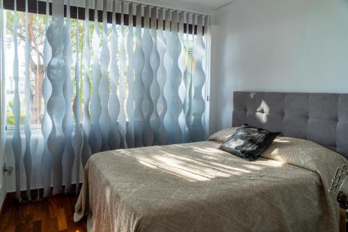 - une chambre avec un lit et une fenêtre avec des rideaux dans l'établissement Luxury apartamento en río real, à Marbella