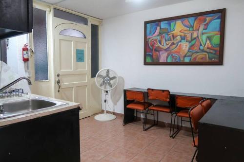a kitchen with a sink and a painting on the wall at Casa Aurora #3: Private room in excellent location in Puerto Vallarta