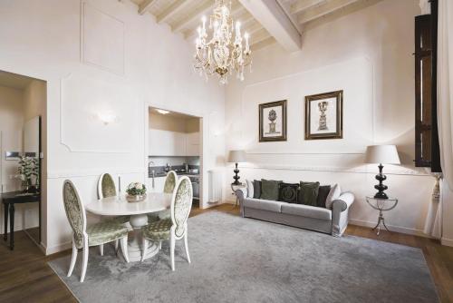 フィレンツェにあるLuxury Apartment Rucellaiのリビングルーム(テーブル、椅子、ソファ付)