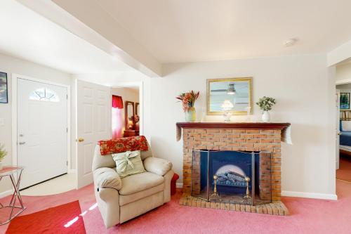 a living room with a fireplace and a chair at Harmon House in Berlin
