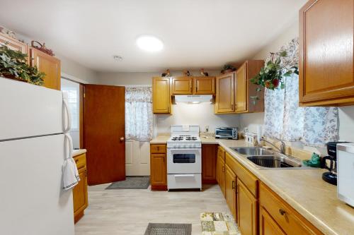 a kitchen with wooden cabinets and a white stove top oven at Harmon House in Berlin