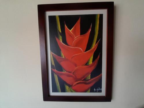 una pintura de una flor roja en una pared en HOSTAL HELICONIAS, en Charalá