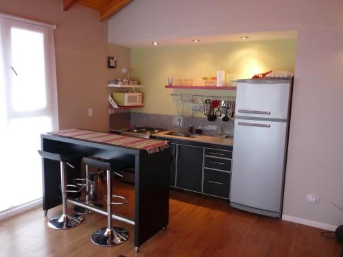 a kitchen with a white refrigerator and a counter at Apartments Seeblick Bariloche in San Carlos de Bariloche
