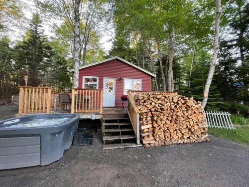 una casa roja con una pila de madera y una bañera en Leland’s Lakehouse, en Wolfville