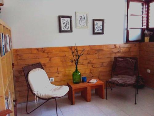 Zimmer mit 2 Stühlen, einem Tisch und einer Vase in der Unterkunft My Place Apt#1 in Praia