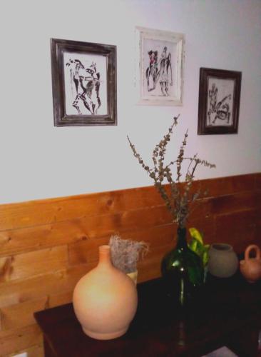 eine Vase auf einem Tisch mit zwei Bildern an der Wand in der Unterkunft My Place Apt#1 in Praia