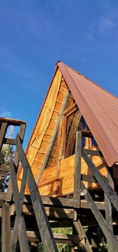 a wooden house with a roof on top of a fence at Glamping Jaulares Mountain in Rivas