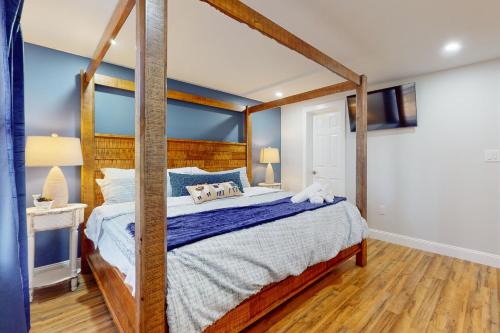ein Schlafzimmer mit einem großen Bett mit einem Holzrahmen in der Unterkunft 1038 Cricket Lane in Long Pond