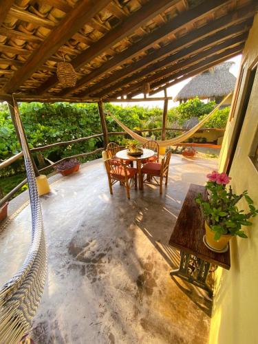 a patio with a table and chairs on a porch at Troncones Point Hostel in Troncones