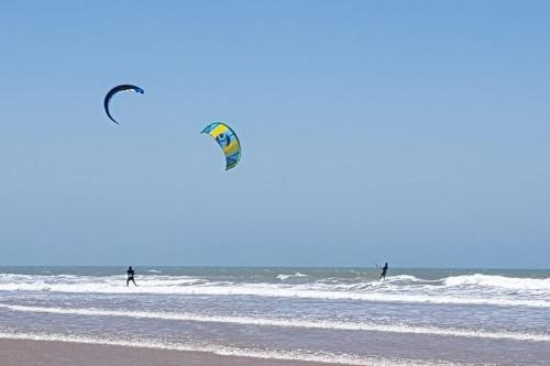 two people on the beach flying a kite at Charmant riad pour familles ou groupes - Dar Mama in Essaouira