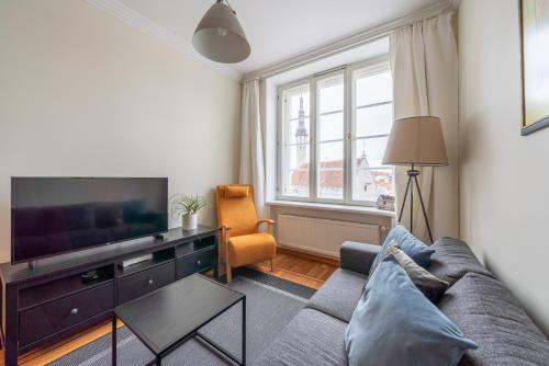 a living room with a couch and a tv at Old Town - Hall Square Apartment in Tallinn