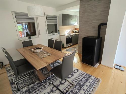 eine Küche und ein Esszimmer mit einem Holztisch und Stühlen in der Unterkunft Planinska kuca NATURA in Vlasic