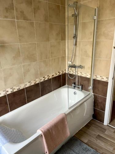a bath tub in a bathroom with a shower at Victorian house between cathedral, river and station in Ely