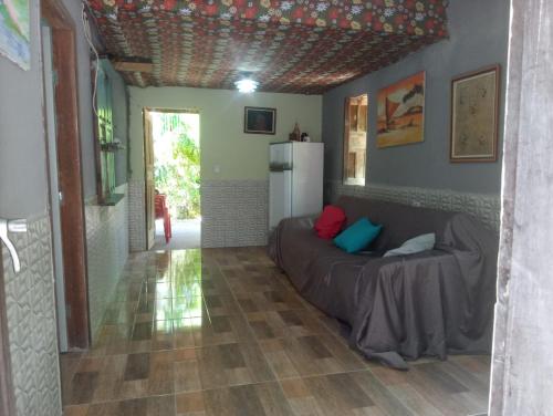 ein Wohnzimmer mit einem Sofa und einem Kühlschrank in der Unterkunft Hospedaria Recanto da Paz in Itaporanga dʼAjuda