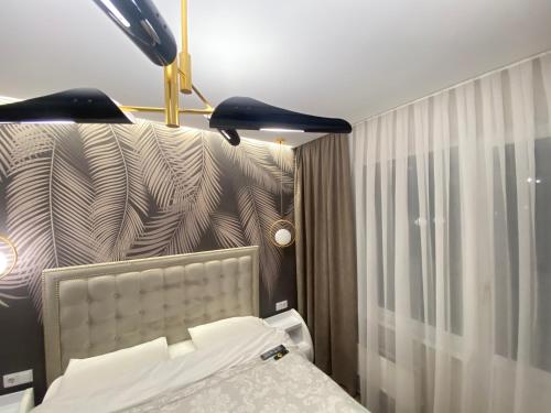 a bedroom with a bed with a headboard and a lamp at Sweethome Ciocana in Chişinău