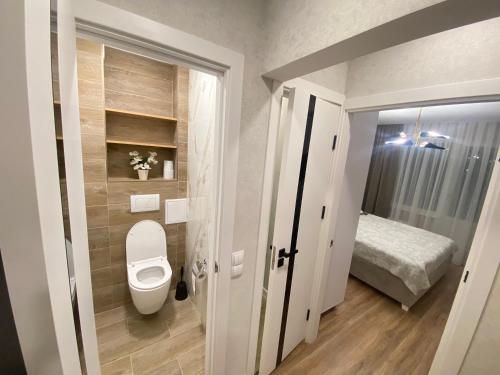a small bathroom with a toilet and a bed at Sweethome Ciocana in Chişinău