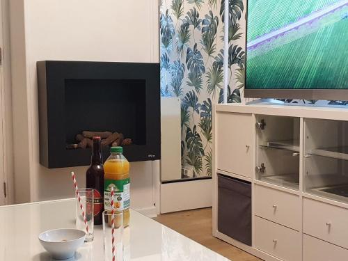 a living room with a television and a table at Maison confortable, terrasse et jardin à Amiens in Amiens