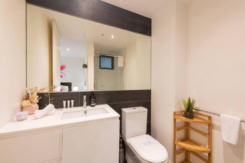 uma casa de banho com um lavatório, um WC e um espelho. em Trendy 2 bed 2 bath Apartment - Heart of St Kilda em Melbourne