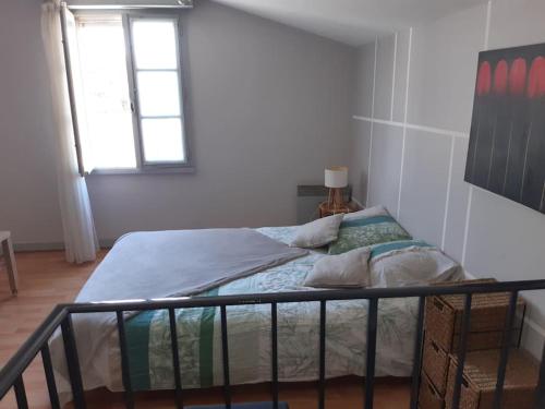 uma cama num quarto branco com uma janela em Maison des Gabelous em Guipry-Messac