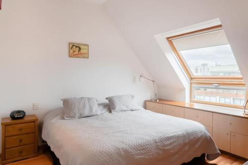 a white bedroom with a bed and a window at Puerto Madero a metros del Faena in Buenos Aires