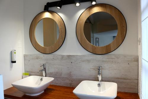 La salle de bains est pourvue de 2 lavabos et de 2 miroirs sur le mur. dans l'établissement Hôtel de Vacances de la Vignasse, à Chandolas