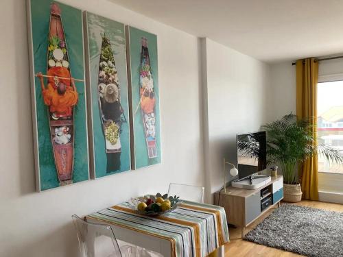 a living room with a table and surfboards on the wall at Milady Ocean View in Biarritz
