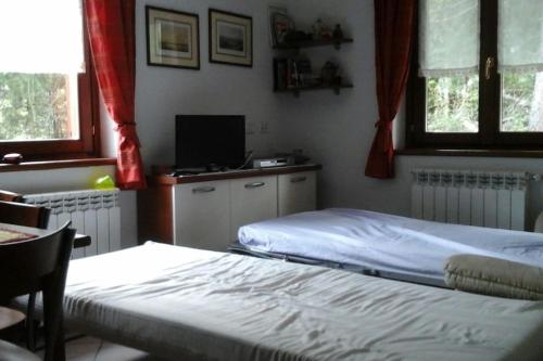 una camera con due letti e una TV e due finestre di Monte Rosa Vacation a Champoluc