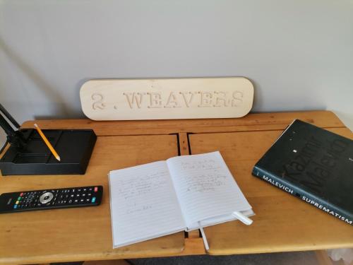a wooden desk with a book and a remote control at The Cross Inn in Hebden Bridge