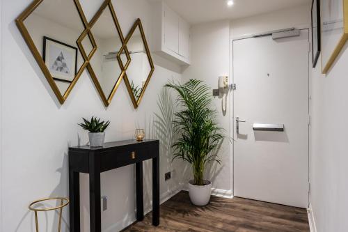 a hallway with a black table and a mirror at Nino Homes Kings cross in London