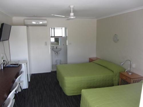 A bed or beds in a room at Urangan Motor Inn