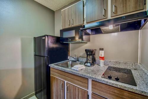 a kitchen with a sink and a refrigerator at Studio 6-Phoenix, AZ - Deer Valley in Phoenix