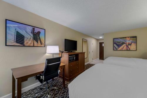 a hotel room with a bed and a desk with a computer at Best Western Plus Wooster Hotel & Conference Center in Wooster