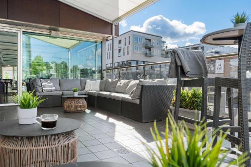patio z kanapą i stołem na balkonie w obiekcie Best Western Plus John Bauer Hotel w mieście Jönköping