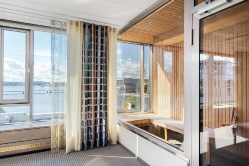 a room with large windows with a view of the water at Best Western Plus John Bauer Hotel in Jönköping