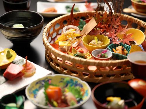 a table with a basket of food and bowls of food at Hotel Tamanoyu in Matsumoto