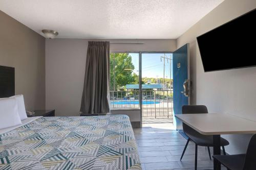 a hotel room with a bed and a desk and a window at Motel 6 Branson West, MO - Silver Dollar City in Branson West