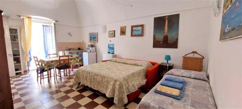 a bedroom with a bed and a table and a kitchen at Bed & Breakfast Porta d'Oriente in Brindisi