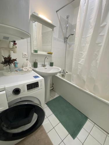 een wasmachine in een badkamer met een wastafel en een bad bij Appartement Chaville in Chaville