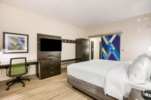 a hotel room with a bed and a desk with a computer at Holiday Inn Express & Suites Jacksonville - Town Center by IHG in Jacksonville