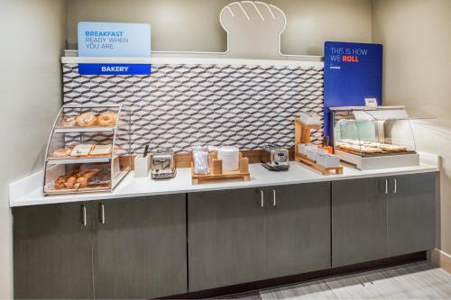 a bakery with a counter with donuts on it at Holiday Inn Express & Suites Jacksonville - Town Center by IHG in Jacksonville