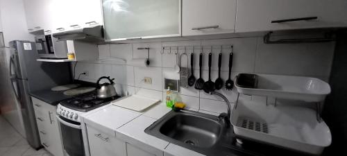 a small kitchen with a sink and a stove at Departamento Jesus Maria in Lima