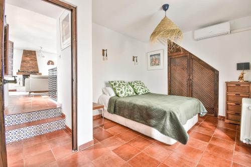 1 dormitorio con cama y espejo en Casa Sol Y Aire - vakantievilla in dorp met privé zwembad, en Pinos del Valle